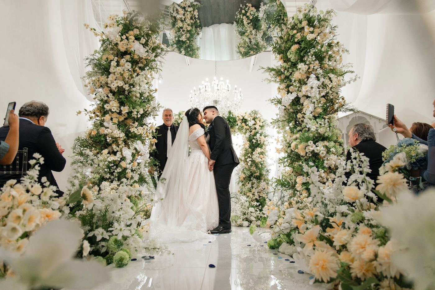 24 Flowers Garden — couple kissing under floral arch during micro wedding