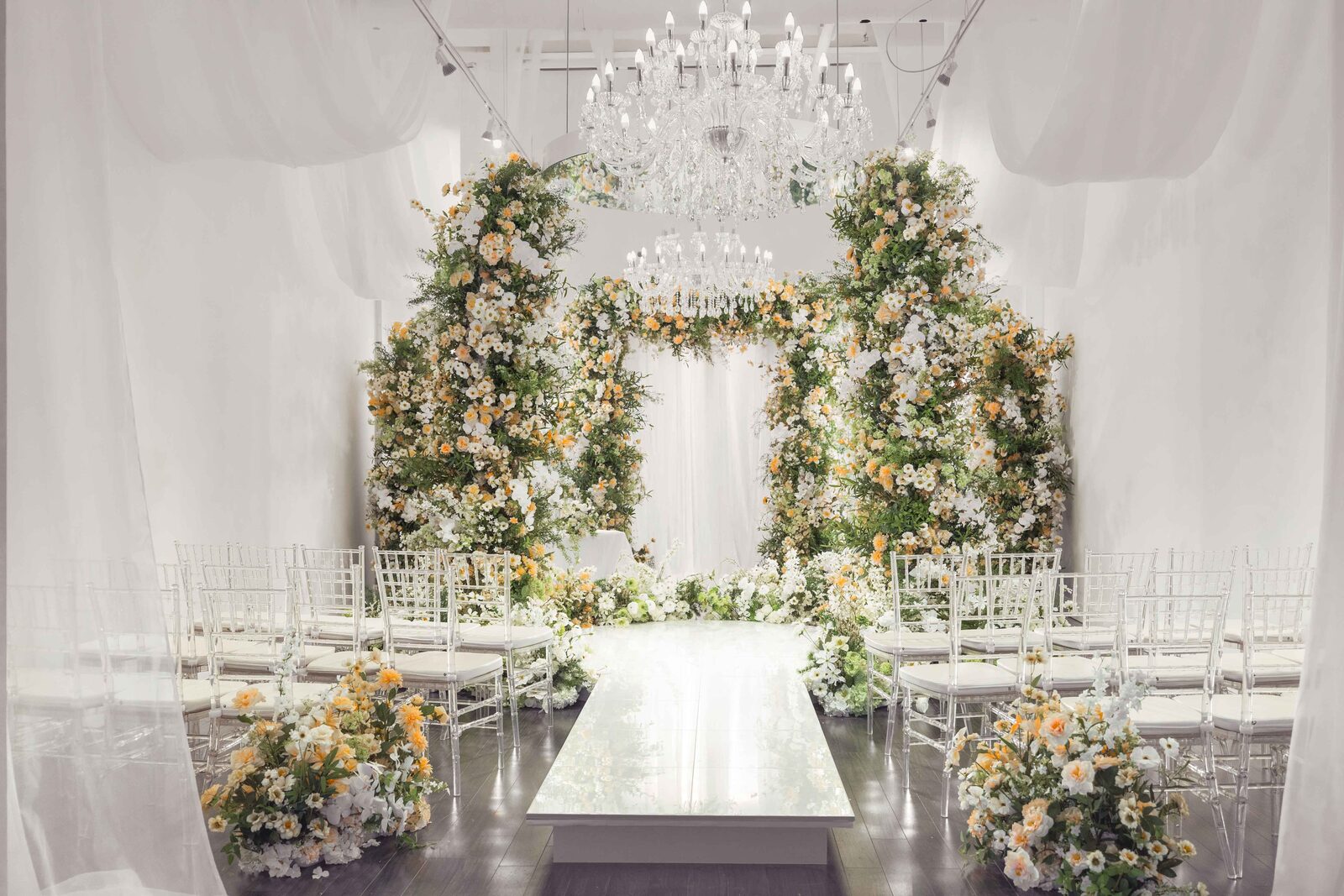 24 Flowers Garden — floral arch ceremony setup with chandelier