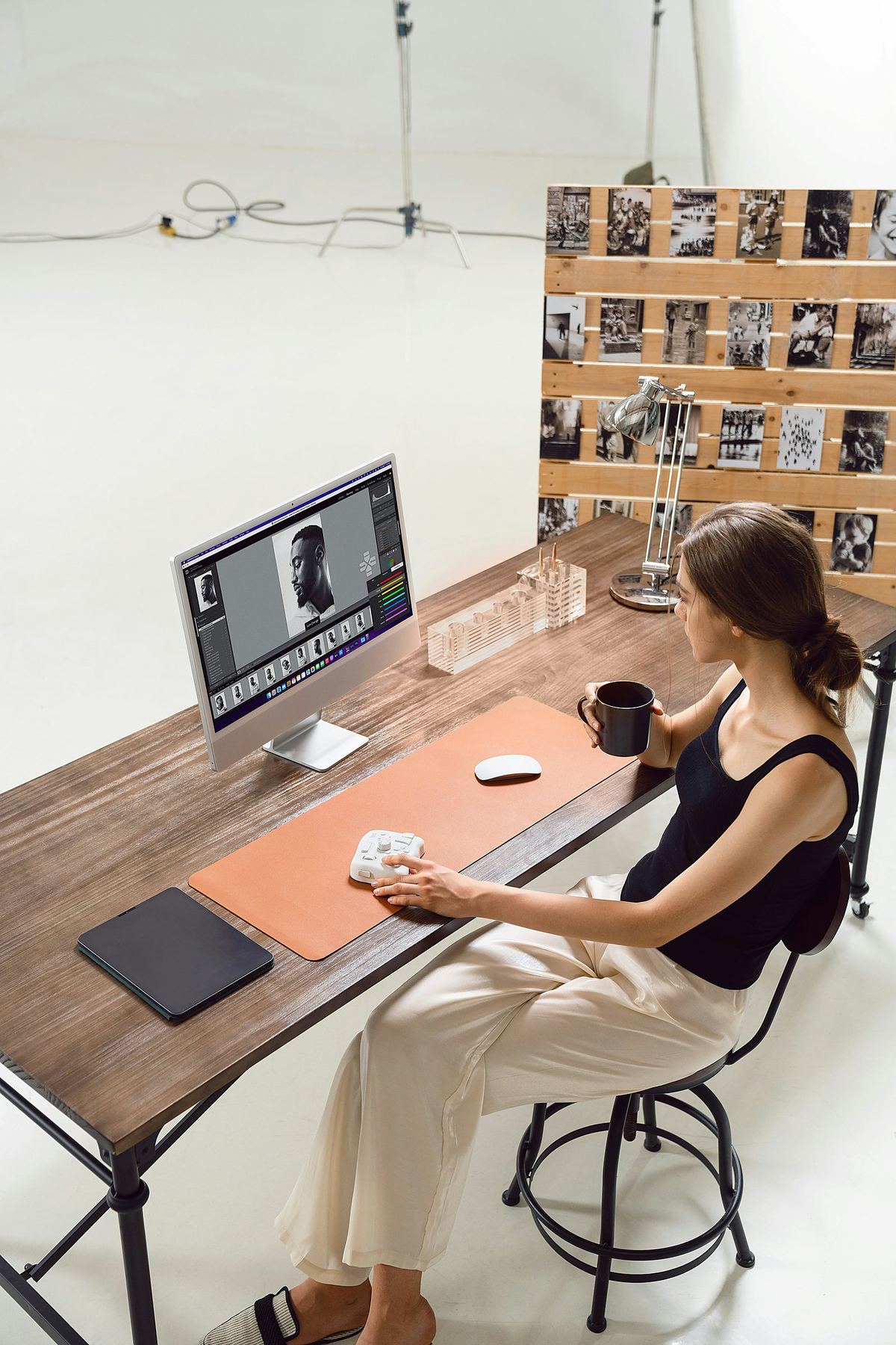 Photographer tethering to laptop while shooting a model on the cyclorama wall at Studio Co